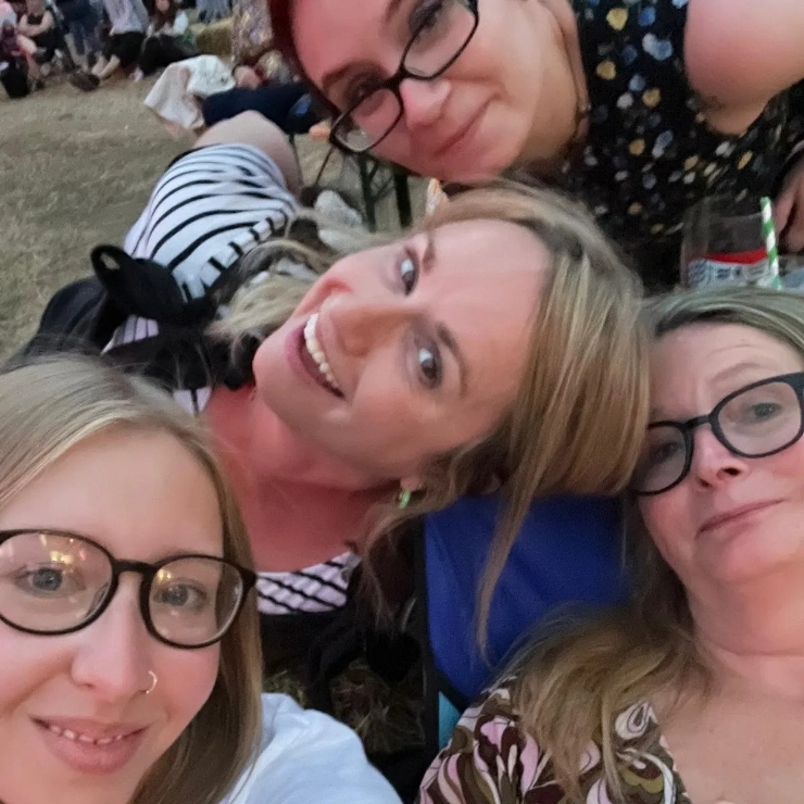 Four women posing for a selfie in a field